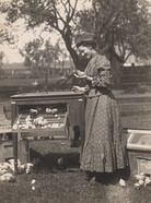 Woman holding baby chick, 1910