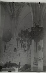 Interior photograph of a Medieval church, family crests hang from the wall