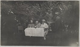 Knut Boije (on the left) sitting at a garden table with a company including Akseli Gallen-Kallela (behind another man on the left).
