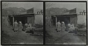 Mary Gallen-Kallela cutting wood with daughter Kirsti watching at home in Taos, New Mexico, ca.1925.